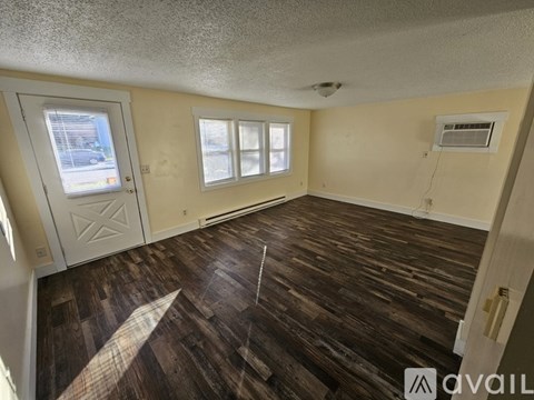 A room with wooden flooring and a window.