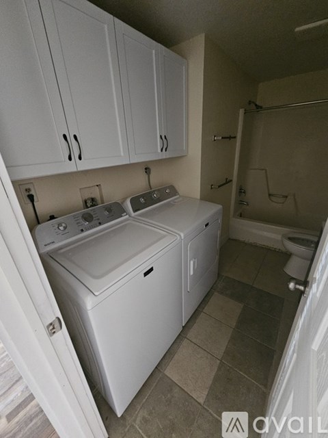 A small laundry room with a washer and dryer.