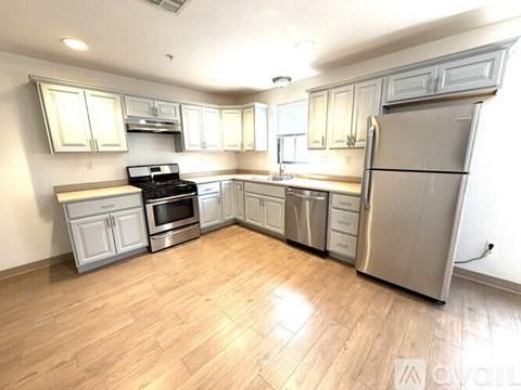 A kitchen with wooden floors and stainless steel appliances.