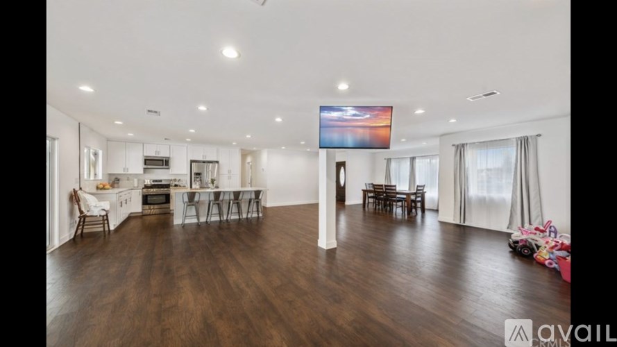 A spacious living room with a television and a dining area.