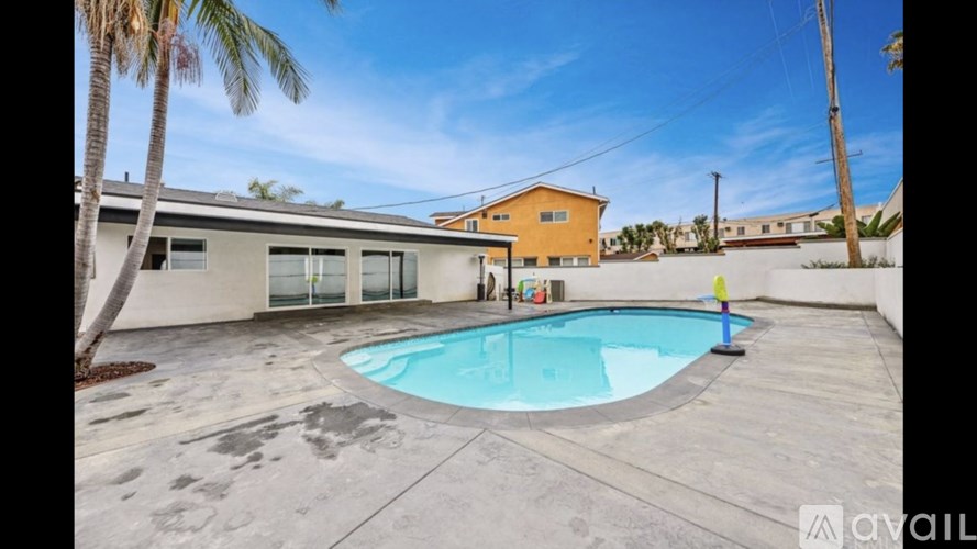 A pool in a backyard with a house in the background.