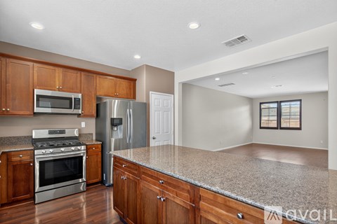 A kitchen with wooden cabinets and stainless steel appliances is available.