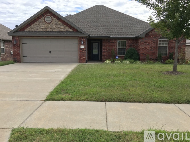 A brick house with a black door and a garage door.