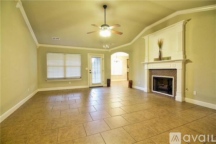 A spacious living room with a fireplace and a ceiling fan.