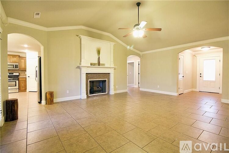 A living room with a fireplace and a ceiling fan.