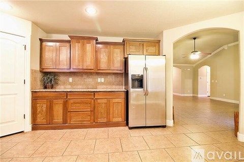 A kitchen with wooden cabinets and a stainless steel refrigerator.