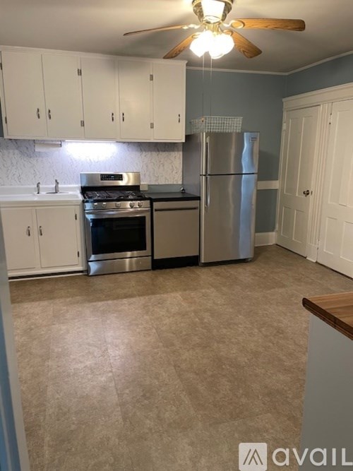 A kitchen with a stove, refrigerator, and cabinets.