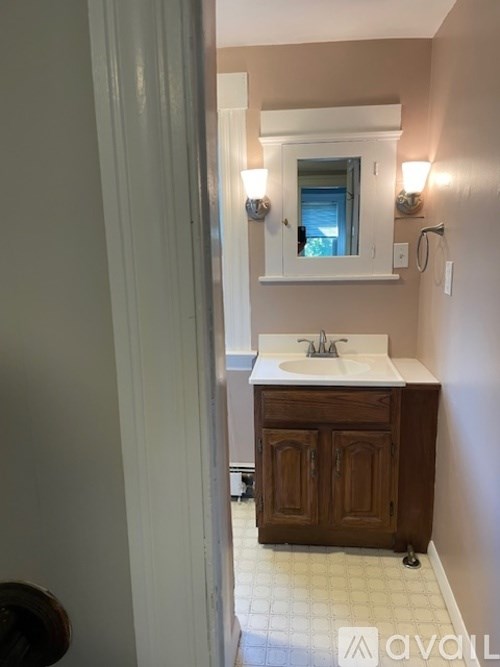 A bathroom with a sink and a mirror above it.