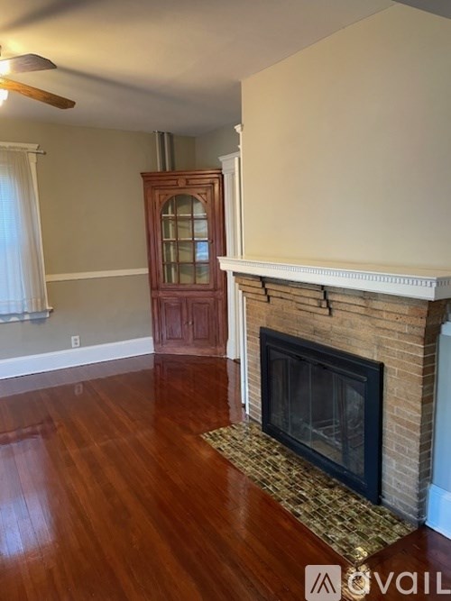 A room with a fireplace and wooden floors.