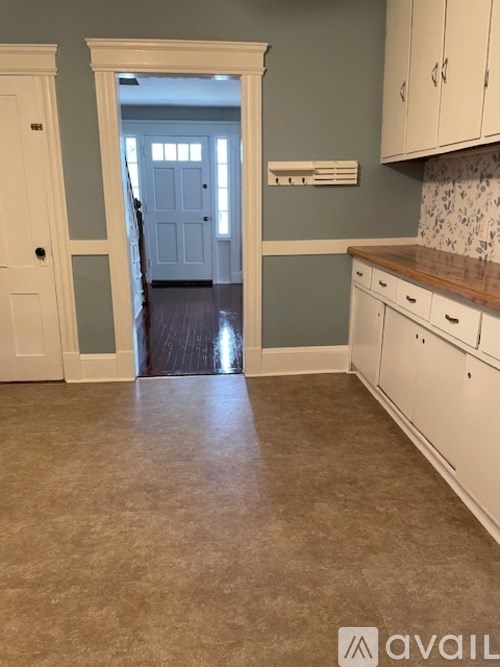 A kitchen with white cabinets and a tiled backsplash.