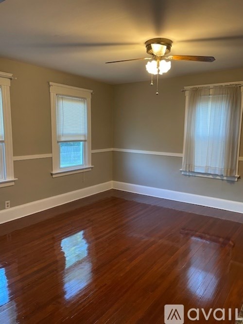 A room with wooden floors and a ceiling fan.