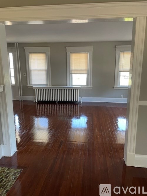 A room with wooden floors and a radiator in the middle.