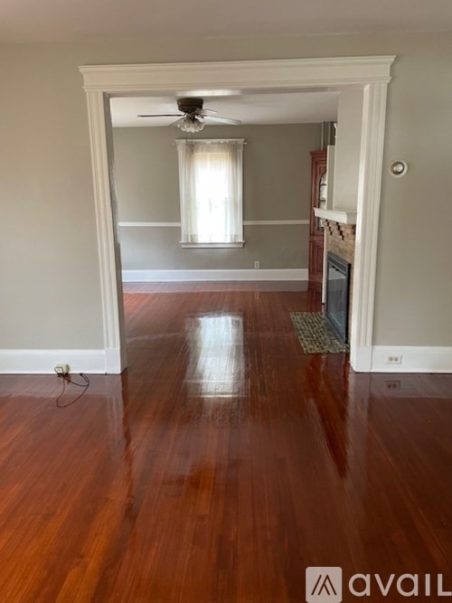 A room with wooden floors and a ceiling fan.