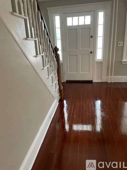 A hallway with a white door and a wooden floor.