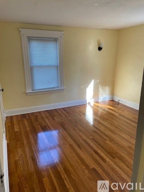 A room with wooden flooring and a window.