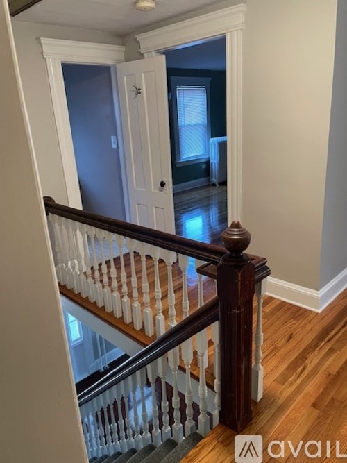 A staircase with a wooden handrail and white balusters.