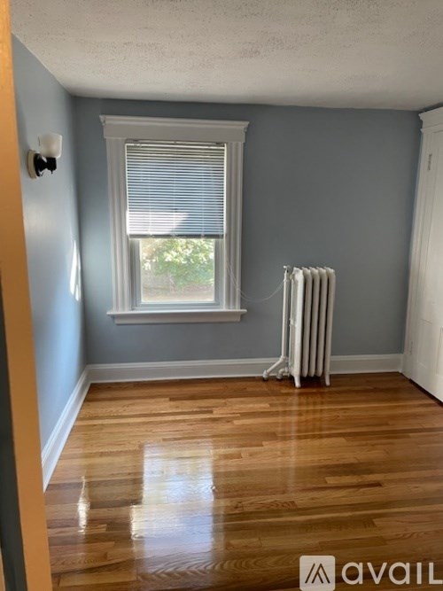 A room with a window and a radiator on the floor.