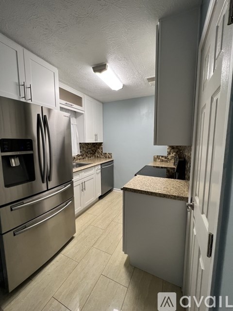 A kitchen with a refrigerator, microwave, and oven.