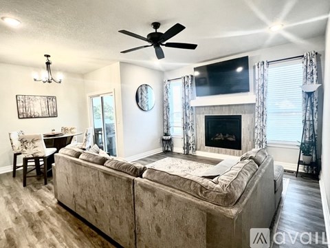 A living room with a large couch and a fireplace.