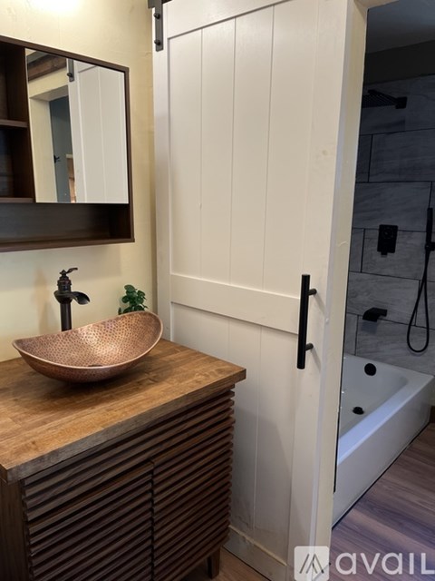 A bathroom with a wooden sink and a mirror above it.