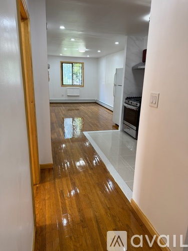 A hallway with wooden floors and a white wall.