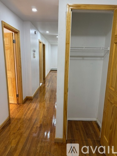 A hallway with wooden floors and white walls.