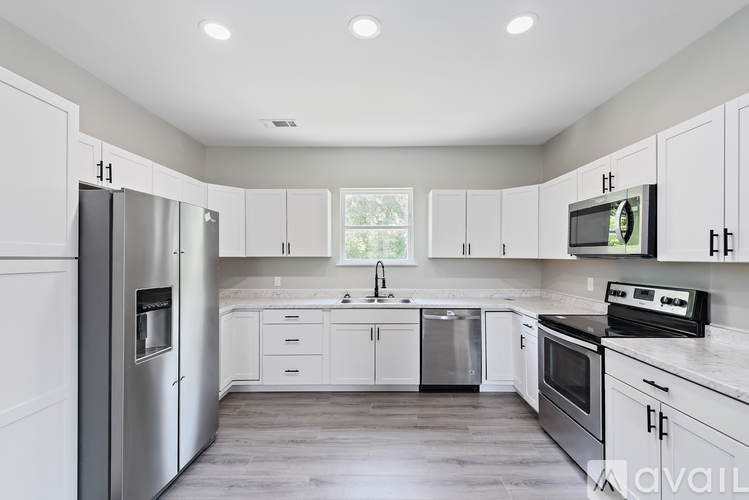 A kitchen with white cabinets and stainless steel appliances.