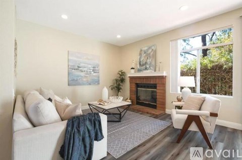 A living room with a fireplace and a painting on the wall.