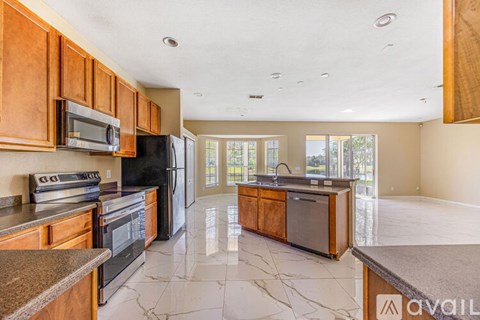 A kitchen with wooden cabinets and black appliances.