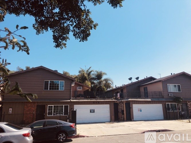A row of houses with garages and a car parked in front.