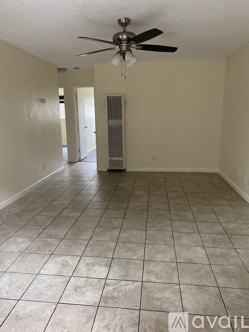 A room with a ceiling fan and tile flooring.
