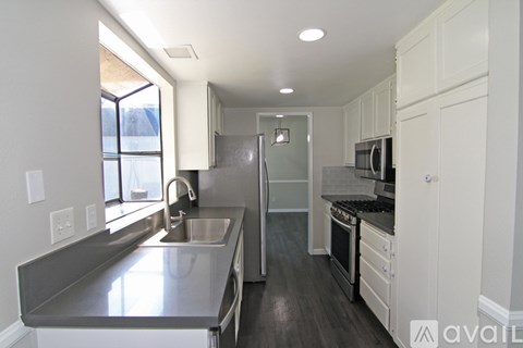 A kitchen with white cabinets and stainless steel appliances.