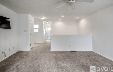 A spacious living room with a television and a carpeted floor.