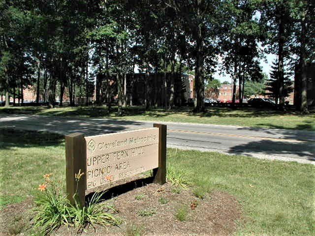 A sign in a grassy area that says "Upper Pen Hill Park".