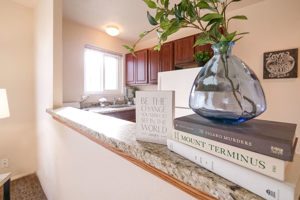 A vase with a plant in it sits on top of a stack of books.