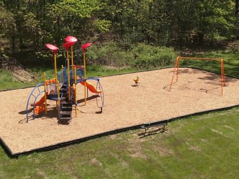 A playground with a slide, swings, and a sandbox.