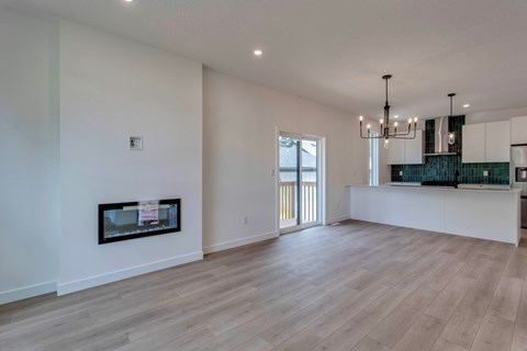 A spacious living room with a fireplace and a chandelier.