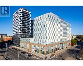 A modern building with a glass facade is situated in a city setting.