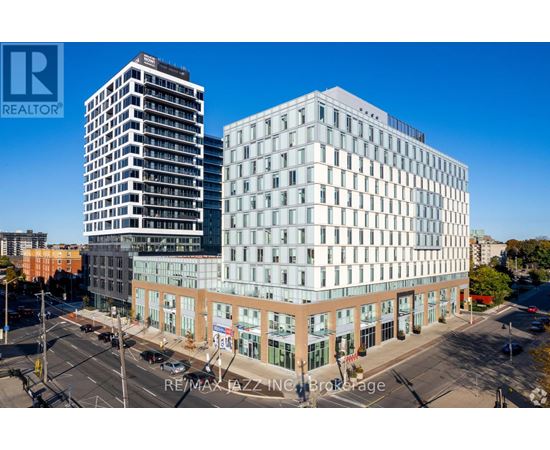 A modern building with a glass facade is situated in a city setting.