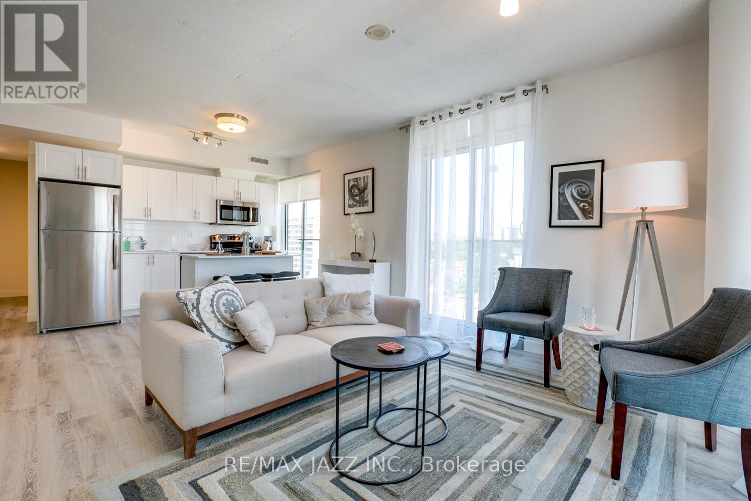 A living room with a couch, chairs, and a coffee table.