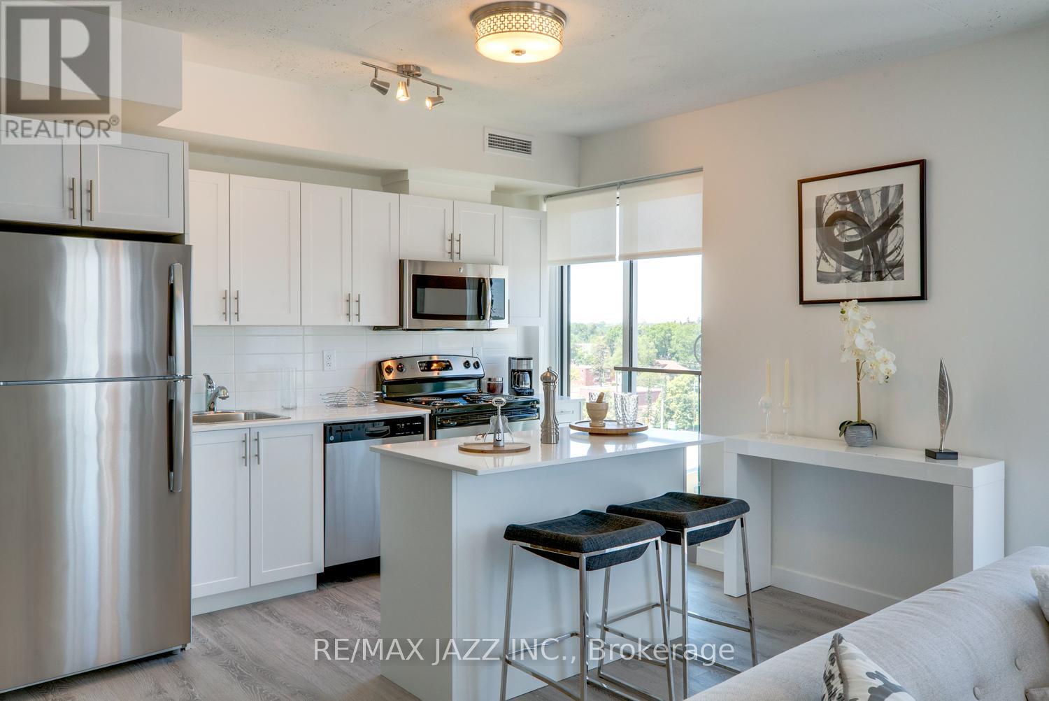 A kitchen with white cabinets and a stainless steel refrigerator.