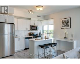 A kitchen with white cabinets and a stainless steel refrigerator.