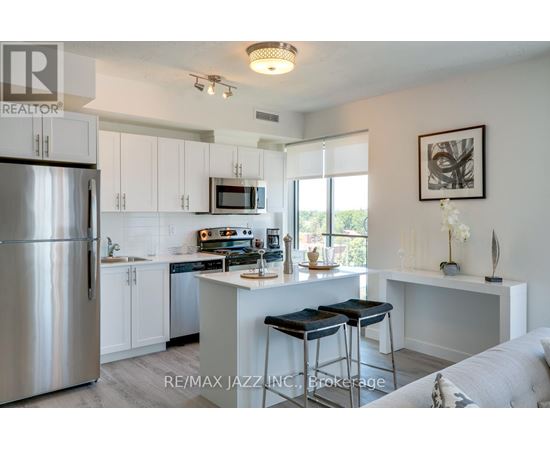 A kitchen with white cabinets and a stainless steel refrigerator.