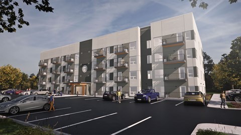 A modern apartment building with cars parked in front.