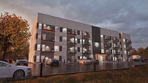 A modern apartment building with cars parked in front.