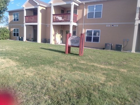 A sign in front of a building that says "Apartments".