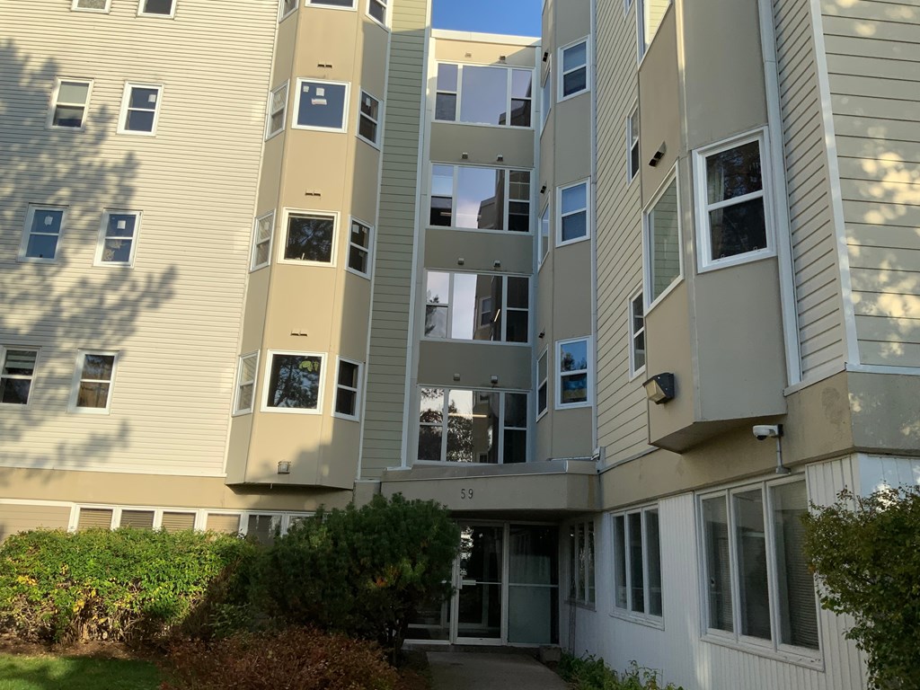 A tall apartment building with a balcony on the second floor.