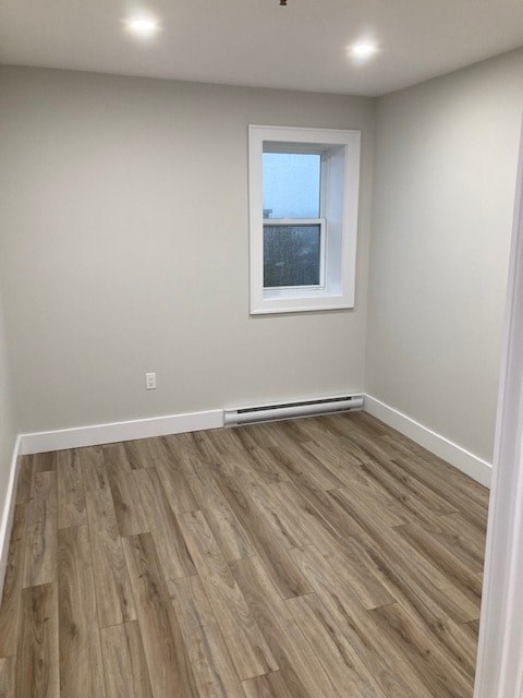 A room with a window and a wooden floor.