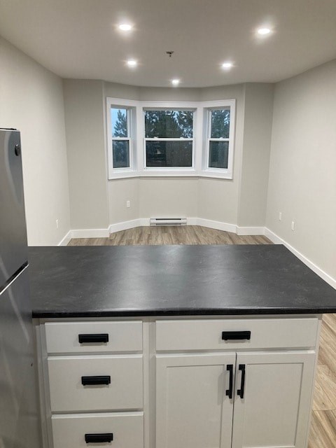 A kitchen with white cabinets and a black countertop.
