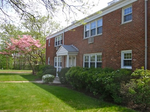 A red brick house with a white door and windows.